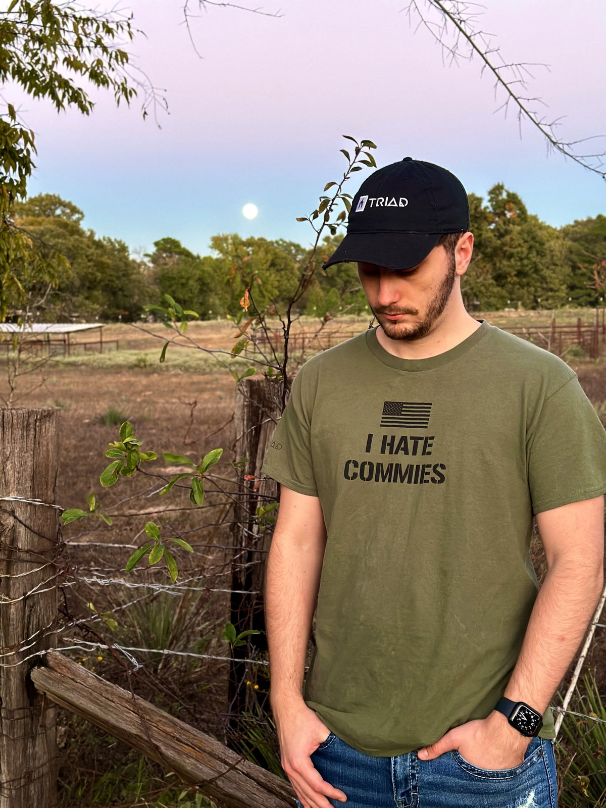 Olive I Hate Commies T-Shirt and Triad cap worn outside at dusk